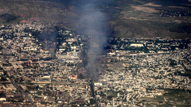 A pall of smoke hangs over the city of Jalal-Abad, the southern Kyrgyz city, Kyrgyzstan, rising from a burning house Monday, June 14, 2010, as seen from a plane window. (AP / Alexander Zemlianichenko)