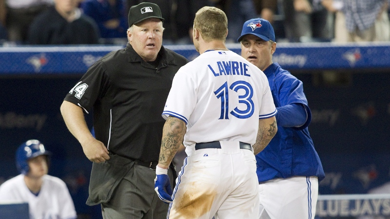 Home Plate Umpire Bill Miller (left) ) reacts as he is confronted by Toronto Blue Jays Brett Lawrie (centre) and Manager John Farrell restrains as he confronted over a strike out call during the ninth inning of MLB baseball action against Tampa Bay Rays in Toronto on Tuesday May 15 , 2012. THE CANADIAN PRESS/Chris Young