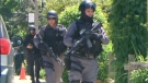 Heavily-armed ETF officers search an east-end neighborhood for a shooting suspect. 