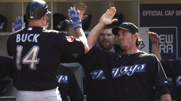 Toronto Blue Jays' John Buck is congratulated upon returning to the dugout after his two-run homer against the San Diego Padres in the fifth inning of a baseball game Wednesday, June 16, 2010, in San Diego. (AP / Lenny Ignelzi)