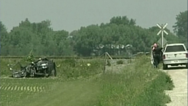 Police are seen at the site of a crash between a train and van that left two children dead near Windsor, Ont., on Sunday, June 10, 2012.