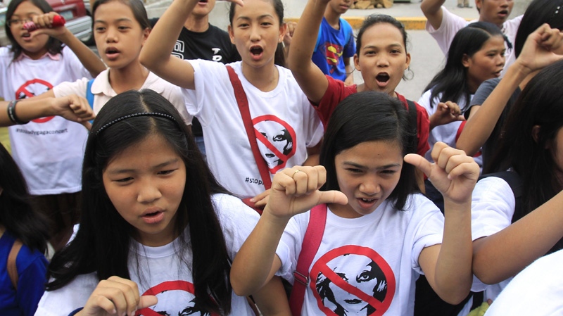 Filipino Christian youths flash the thumbs-down signs as they chant "Stop the Lady Gaga concerts" during a rally, calling for the cancellation of the singer's May 21-22 concerts, outside the Pasay City Hall in Pasay, south of Manila, Philippines, Friday, May 18, 2012. (AP Photo/Bullit Marquez)