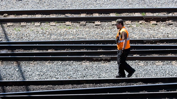 A Canadian Pacific Railway employee walks along the track at a marshalling yard in Calgary, Wednesday, May 16, 2012. (Jeff McIntosh / THE CANADIAN PRESS)