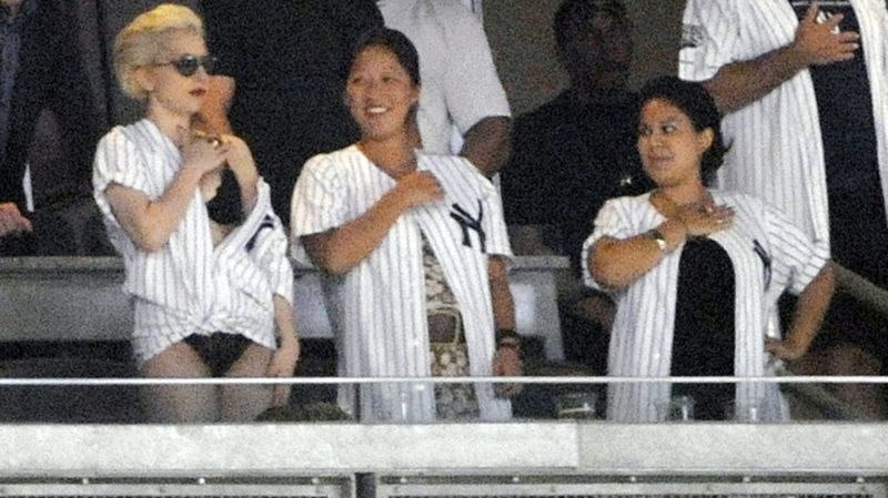 Lady Gaga stands for 'God Bless America' during the seventh inning stretch as the New York Yankees play the New York Mets in a baseball game Friday, June 18, 2010 at Yankee Stadium in New York. (AP / Bill Kostroun) 