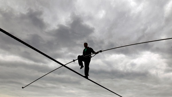 Nik Wallenda performs a walk on a tightrope in the rain during training for his walk over Niagara Falls in Niagara Falls, N.Y. May 16, 2012.  (AP / David Duprey)