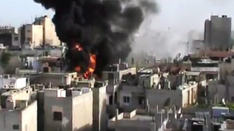 A building is on fire from shelling in Homs province, Syria, on Wednesday, May 23, 2012. (Shaam News Network via AP video) 