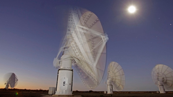 In this time exposure photo taken Monday, April 2, 2012, the moon and stars are seen above telescope dishes near the Karoo town of Carnarvon, South Africa, which is announced Friday May 25, 2012, as the site of the proposed Square Kilometre Array (SKA) radio telescope project. A giant radio telescope made up of some 3,000 separate 15-meter (49-foot) diameter dishes and intended to help scientists answer fundamental questions about the make-up of the universe will be built and based in both Australia and South Africa, the international consortium overseeing the project announced Friday. (AP Photo/Schalk van Zuydam) EDS NOTE: TIME EXPOSURE CAUSING BLUR AS TELESCOPE DISHES MOVE