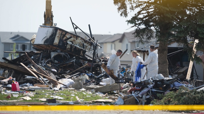 Edmonton Police Service investigators comb through through the rubble of a residential explosion scene, in an Edmonton neighbourhood, Monday June 21, 2010. (John Ulan / THE CANADIAN PRESS)  