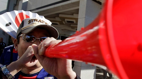 A Japanese fan blows a vuvuzela in Durban beach, South Africa, Saturday, June 19, 2010. Durban later the day will host a Group E World Cup match between Japan and the Netherlands. (AP Photo/Thanassis Stavrakis)