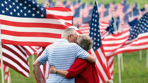 World War II veteran Jesse R. Turner embraces Helen Marie Misel at a display of over more than 1700 United States flags in Shawnee, Kan., Saturday, May 26, 2012. (AP / Orlin Wagner)