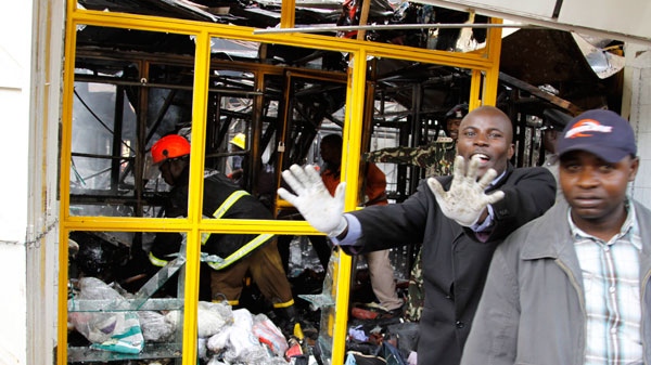 A plain clothed police officer reacts as fire officers sort through the debris of a building after an explosion in Nairobi, Kenya, Monday, May 28, 2012. (AP / Khalil Senosi)