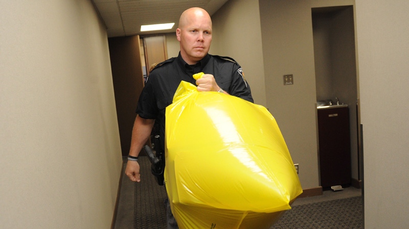 A police officer removes a package containing a human foot from the Conservative Party headquarters in Ottawa on Tuesday, May 29, 2012. (Sean Kilpatrick / THE CANADIAN PRESS)