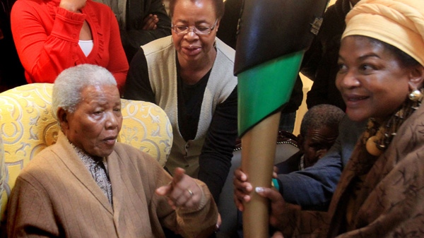 South Africa's former president Nelson Mandela, left, receiving a torch to celebrate the African National Congress' centenary from ANC chairperson Baleka Mbete, right, in Mandela's home village Qunu in rural eastern South Africa Wednesday May 30, 2012. (AP / Lulamile Feni-Daily Dispatch) 