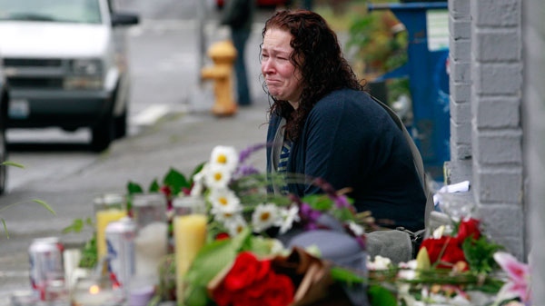 Stacy Davis cries as she sits near a growing memorial at the scene of where a gunman killed four people and severely wounded another in a cafe a day earlier in Seattle, Washington, Thursday, May 31, 2012. (AP / Elaine Thompson)