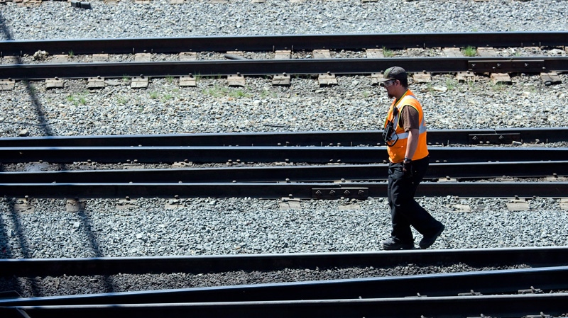 A Canadian Pacific Railway employee walks along the track at a marshalling yard in Calgary, Wednesday, May 16, 2012. (Jeff McIntosh / THE CANADIAN PRESS)