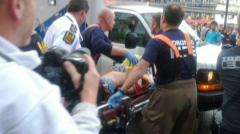 A victim is seen being rushed to the hospital following a shooting at Eaton Centre in Toronto, Saturday, June 2, 2012.