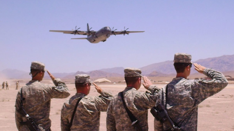An Australian C130 takes off carrying the bodies of two Australian soldiers who were killed by an improvised explosive device in southern Afghanistan as members of the US Army 101st Aviation Group salute during take off in Tarin Kowt, Afghanistan on Wednesday, June 9, 2010. (AP / Jim St. Pierre) 