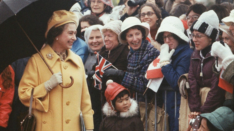 Queen Elizabeth II smiles as a spectator takes a photograph of her on Parliament Hill in Ottawa, Oct. 16, 1977. (Fred Chartrand / THE CANADIAN PRESS)