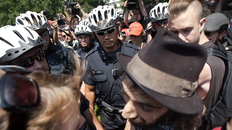 Activists and protesters are confronted by police as they argue for not providing identification before marching along the streets of downtown Toronto during the, Friday, June 25, 2010. (Nathan Denette / THE CANADIAN PRESS)  