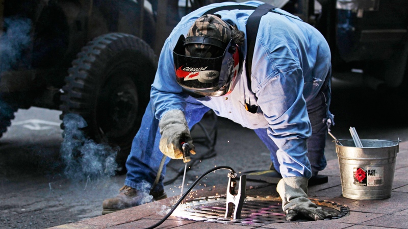 Mike Boyle welds a manhole shut along Bay Street in downtown Toronto, Sunday, June 27, 2010, as an additional security measure in the wake of riots in downtown Toronto the night before during the G20 Summit. (AP / Carolyn Kaster)