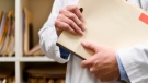 A doctor holds files in this undated stock photo.