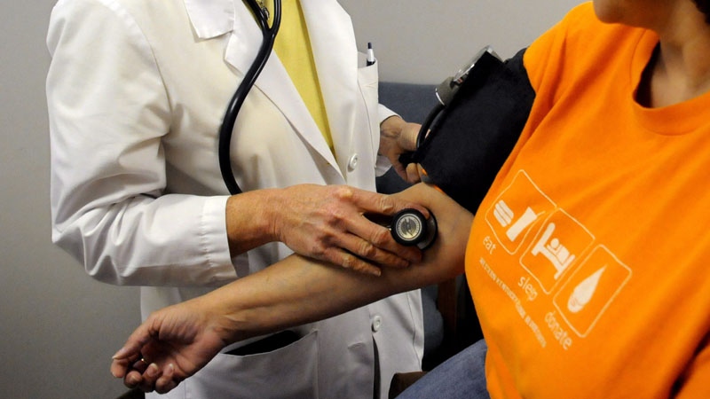 A nurse practitioner checks blood pressure 