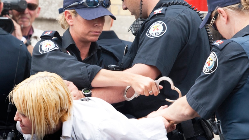 A woman is arrested as she was waiting outside Toronto's detention centre during the G20 summit Sunday, June 27, 2010 in Toronto. (Jacques Boissinot / THE CANADIAN PRESS)