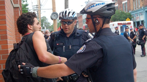 Anti-G20 protester Dionysos Savopoulos is detained by police on Sunday afternoon in Toronto, after spending the night in a temporary detention facility, Sunday, June 27, 2010.