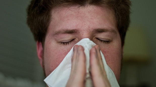 Man blows his nose from common cold