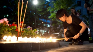 Members of the Chinese community hold a candlelight vigil for Jun Lin, whose dismembered body was found last month, in Montreal Thursday, June 14, 2012 in Montreal. THE CANADIAN PRESS/Paul Chiasson