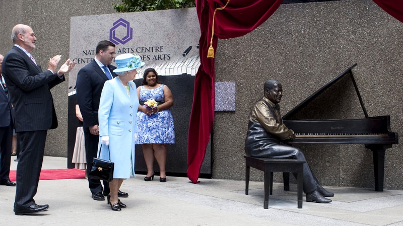 Queen Elizabeth takes part in the unveiling of a statue of Canadian jazz legend Oscar Peterson in Ottawa on June 30, 2010. Oscar Peterson's daughter Celine looks on at back. (Sean Kilpatrick / THE CANADIAN PRESS)