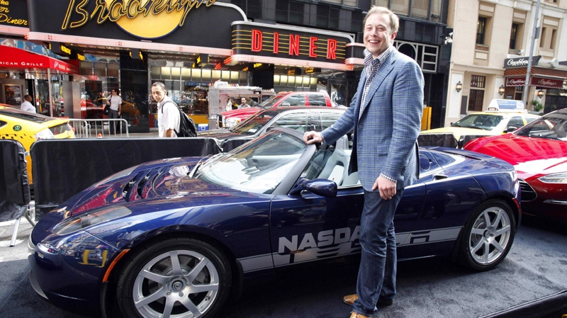 Elon Musk, CEO of Tesla Motors, poses with a Tesla car in Times Square following the electric automaker's initial public offering, Tuesday, June, 29, 2010, in New York. (AP Photo/Mark Lennihan)