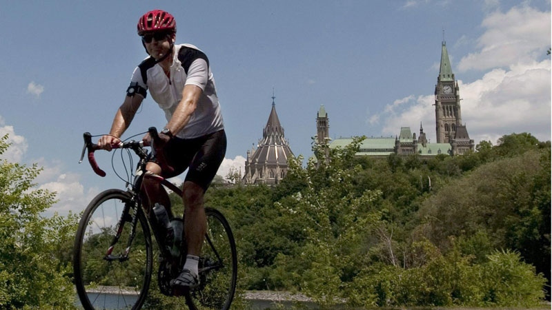 A cyclist rides with a helmet near Parliament Hill 