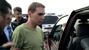 Luka Rocco Magnotta is taken by police from a Canadian military plane to a waiting van in Mirabel, Que., on Monday, June 18, 2012. 