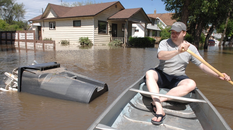 Mark Lints rows down Agricultural Street following a torrential downpour that caused flooding in Yorkton, Saskatchewan on Friday, July 2, 2010. (Mark Taylor /  THE CANADIAN PRESS)