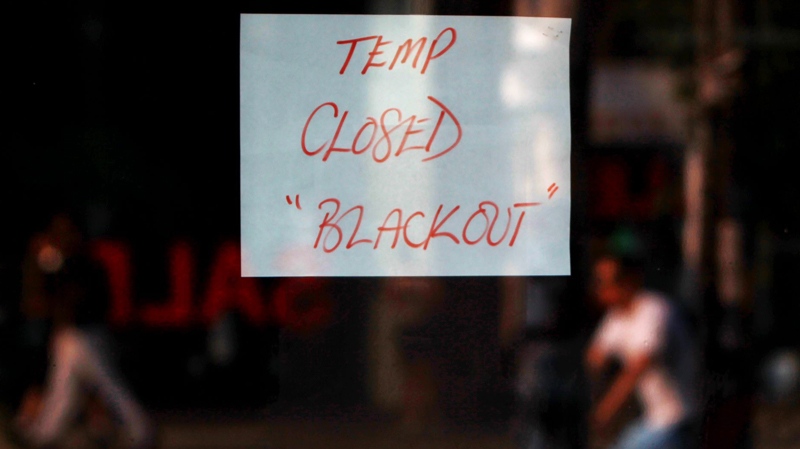A sign on a Queen Street West storefront notifies shoppers of its closure due to a major power outage in Toronto Monday, July 5, 2010. (Darren Calabrese / THE CANADIAN PRESS)