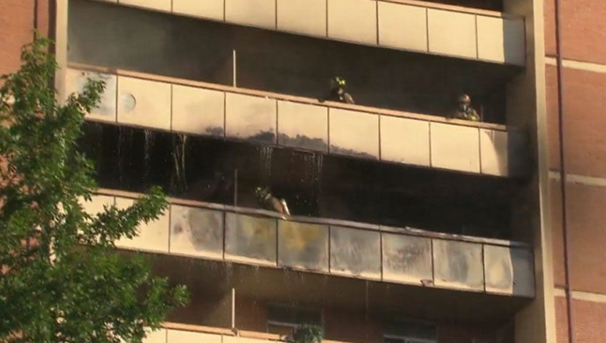 Firefighters work to put out a fire at an apartment building in Toronto on June 26, 2012