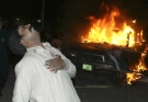 A supporter of Bhutto cries out aloud as he mourns her assassination, as a car burns after being set afire by protesters, in Lahore, Pakistan on Thursday, Dec. 27, 2007. (AP / K.M.Chaudary)
