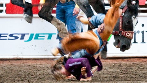 Brittany Mercier of Airdrie, Alta.,gets bucked off her horse during novice bareback rodeo action at the Calgary Stampede in Calgary, Monday, July 12, 2010. (Jeff McIntosh / THE CANADIAN PRESS)