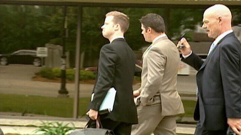 Waterloo Regional Police Service Const. Andrew Robson , centre, is facing a trial.