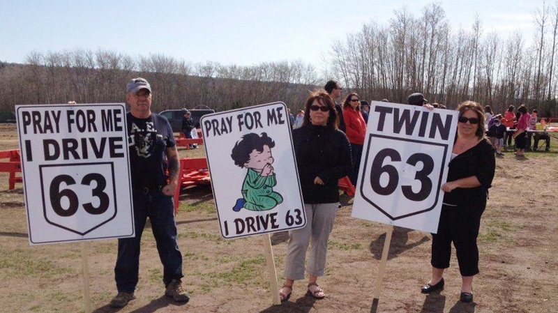 Protesters hold signs at a rally in Fort McMurray, Alta. on May 5, 2012.
