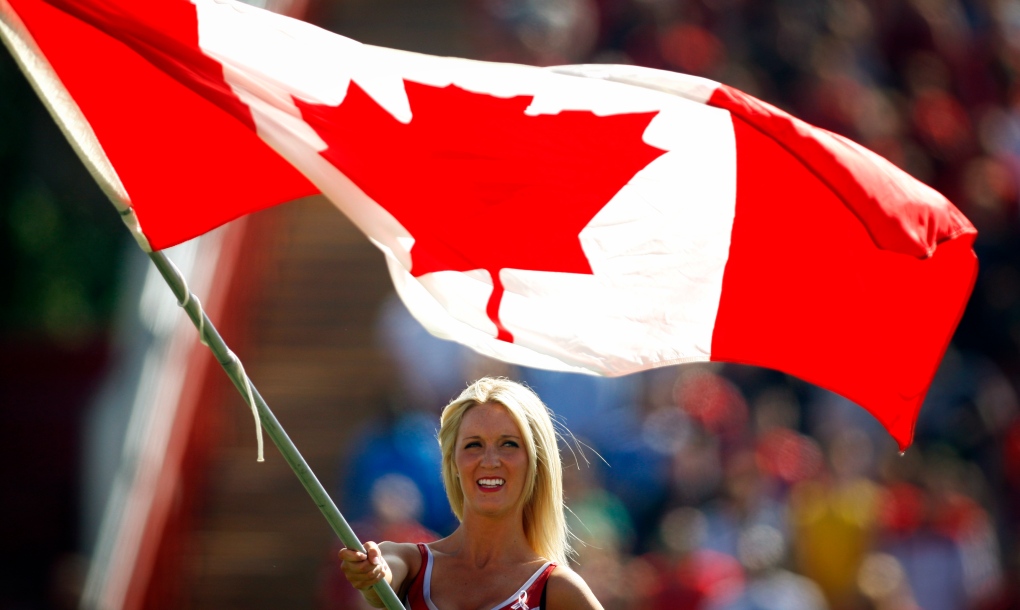 A Calgary Stampeders' Outrider flies the Canadian flag on Canada Day