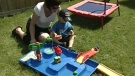A young boy plays with this water table sold at Tag Along Toys.