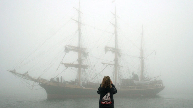 Torunn Andersen takes a photo of the Picton Castle as it rolls in through the fog for the Tall Ships Nova Scotia Festival in Halifax, Nova Scotia on Thursday, July 12, 2007. (CP PHOTO/Ryan Taplin) 