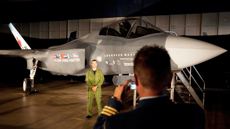 A Canadian Forces pilot has his picture taken in front of a F-35 Strike Fighter prior to an announcement in Ottawa, Friday July 16, 2010.  (Adrian Wyld / THE CANADIAN PRESS)