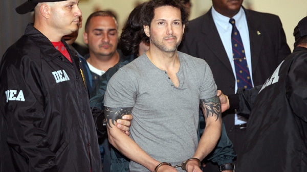 Jose Figueroa Agosto is escorted handcuffed by DEA agents after his arrest in San Juan, Saturday July 17, 2010. Federal authorities arrested fugitive alleged drug kingpin Jose Figueroa Agosto Saturday after a decade-long chase through the Caribbean. (AP Photo/El Nuevo Dia, Tania Dumas) 