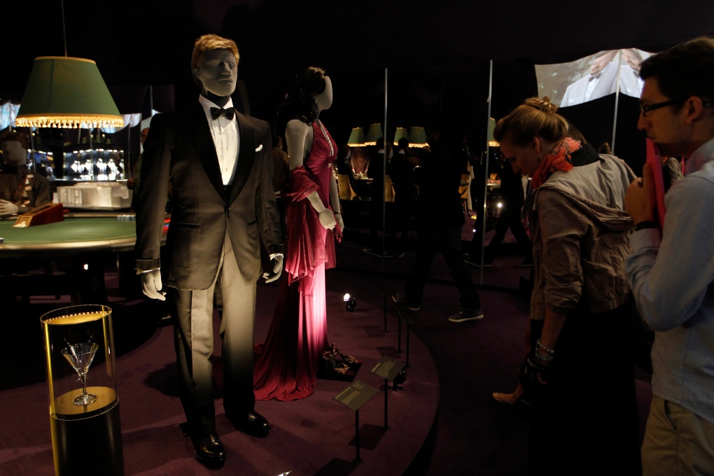 Visitors look at a tuxedo worn by James Bond 