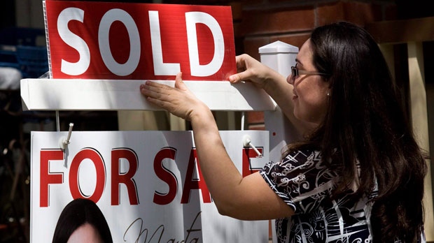 A real estate agent puts up a "sold" sign in front of a house in Toronto Tuesday, April 20, 2010. (The Canadian Press/Darren Calabrese)