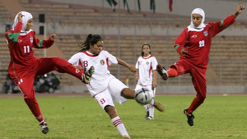 In this Oct. 1, 2005 file photo, Iranian players Saedeh Ahmadi, left, and Shihrin Nasiri, right, , battle for ball with Stephanie Al-Naber, center, of Jordan. (AP Photo/ Muhammad Al-Kisswany, File)