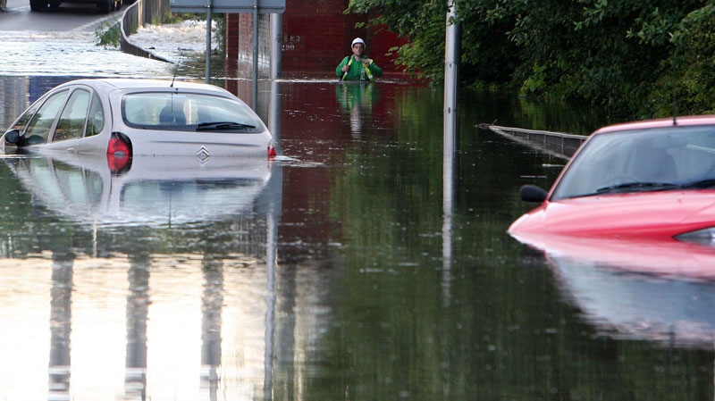 A man walks through flood water as torrential downpours cause flash floods in Jarrow, England.